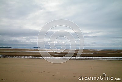 A sandy beach exposed by a receding tide. Stock Photo