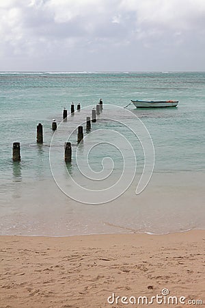 Sandy coast, destroyed pier and boat. Anse de Sent-An, Pointe-a-Pitre, Guadeloupe Stock Photo