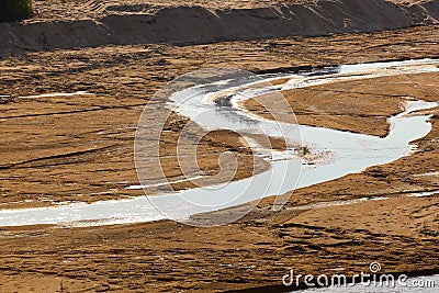 Sandy landscape view with a curvy flowing stream of water South Africa Stock Photo