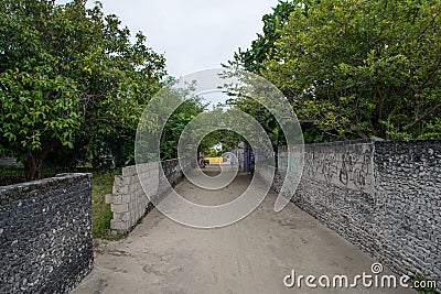 Sandy road and fences made from coral rocks Stock Photo