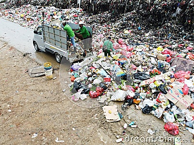 A landfill worker doing his job in landfill site Editorial Stock Photo