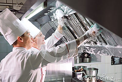 Sanitary day in the restaurant. Repeats wash your workplace. Cooks wash oven, stove and extractor in the Restaurant. Stock Photo