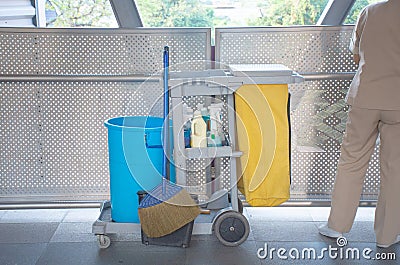 Sanitary set on tray with cleaning man, bottle of hygiene liquid with mop and bloom and bin for clean public area Stock Photo