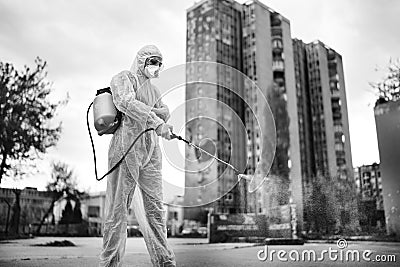Sanitation service worker disinfecting public space with disinfectant spray.Street disinfection.Coronavirus COVID-19 pandemic Stock Photo