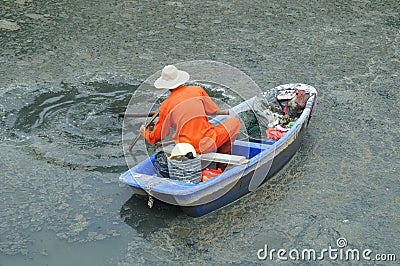 Sanitation workers clean up the rubbish in the river Stock Photo