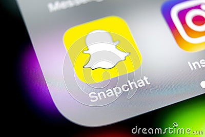 Snapchat application icon on Apple iPhone X smartphone screen close-up. Snapchat app icon. Social media icon. Social network Editorial Stock Photo