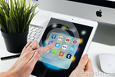 Woman Hands using iPad pro with icons of social media facebook, instagram, twitter, google application on screen. Smartphone Start Editorial Stock Photo