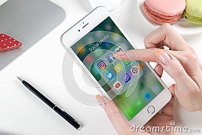 Woman Hands using smartphone with icons of social media facebook, instagram, twitter, google application on screen. Smartphone Editorial Stock Photo