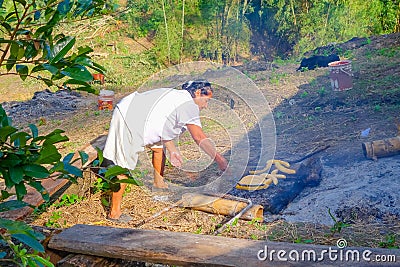 Santa Ana, Ecuador - May 07, 2017: Closeup of an unidentified indigenous Ecuadorian woman wearing white clothes, grilled Editorial Stock Photo