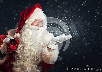 Santa Claus blowing snow of his hands Stock Photo