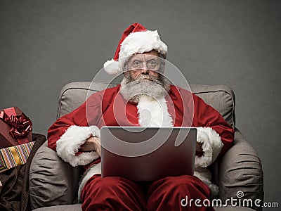 Santa Claus connecting with a laptop Stock Photo