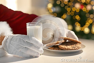 Santa Claus eating cookies and drinking milk at table, closeup Stock Photo