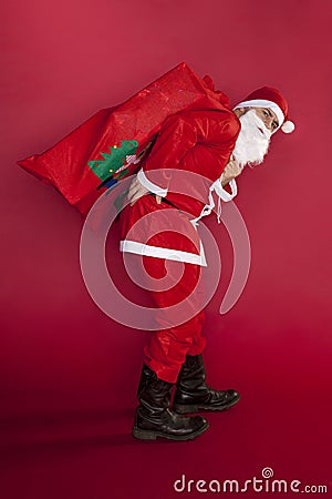 Santa Claus has back pain from the weight of gifts Stock Photo