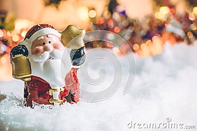 Santa claus hold the bell and star stand among pile of snow at silent night, light up the hopefulness and happiness in Merry chri Stock Photo