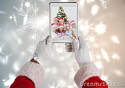 Santa claus holding a digital tablet with photo of christmas family Stock Photo
