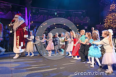 Santa Claus leads the children a cheerful holiday dances. Christmas night. Santa Claus on stage. Editorial Stock Photo