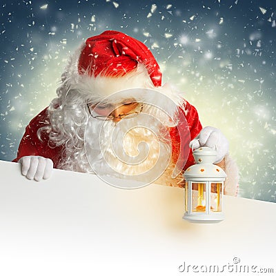 Santa Claus looking down on white blank banner holding Stock Photo