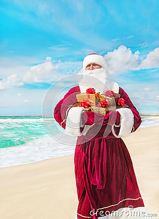 Santa Claus with many golden gifts on sea beach Stock Photo