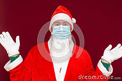 Santa Claus medical mask says there is no gift empty with his hands on red background Stock Photo