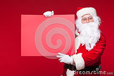 Santa Claus pointing in blank advertisement banner isolated on red background with copy space red leaf Stock Photo