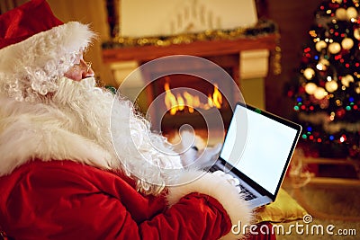 Santa Claus reading email on laptop with Christmas requesting Stock Photo