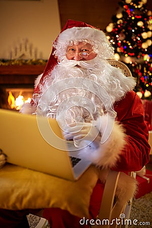 Santa Claus reading email on laptop requesting wish present list Stock Photo