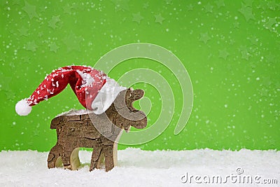 Santa Claus with red hat - wooden deer on green christmas background. Stock Photo