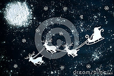 Santa Claus and reindeer flying through the night sky. Stock Photo