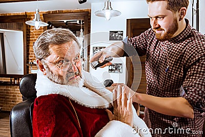 Santa claus shaving his personal barber Stock Photo