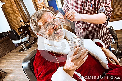 Santa claus shaving his personal barber Stock Photo