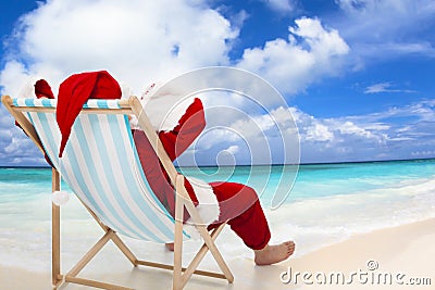 Santa Claus sitting on beach chairs. Christmas holiday concept. Stock Photo