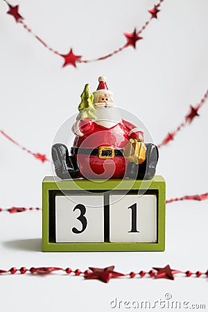 Santa claus sitting on cubes showing the date thirty first on white background with red garland Stock Photo