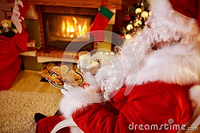 Santa Claus sitting and enjoying in cookies and milk Stock Photo