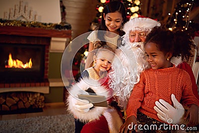 Santa Claus taking selfie during Christmas atmosphere with child Stock Photo