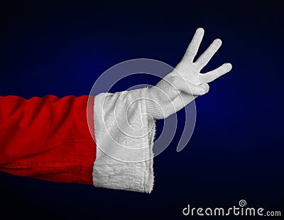Santa Claus theme: Santa's hand showing gesture on a dark blue background Stock Photo