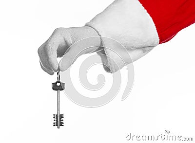 Santa Claus topic: Hand santa holds the keys to a new apartment or a new house on a white background Stock Photo