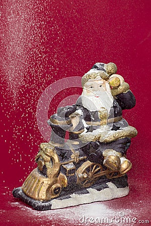 Decorative Santa figurine and snowing on red background Stock Photo