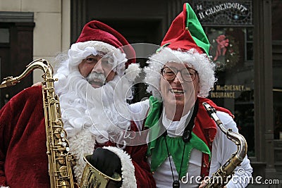 Santa and his elf with saxophones at Victorian Stroll Editorial Stock Photo