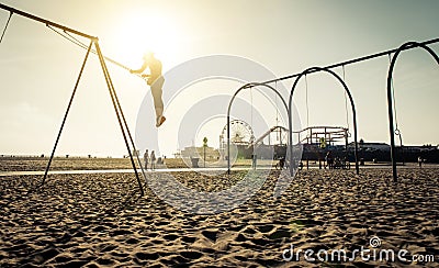 Santa monica beach. silhouette of a woman going up with the swing Stock Photo