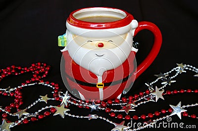 Santa mug with hot drink and shiny string beads in front of it Stock Photo