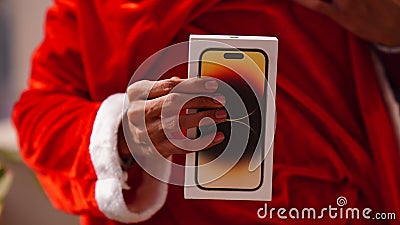 santa showing Iphone 14 pro in santa's hand gift iphone apple products new launch of apple 14 pro phone box Editorial Stock Photo