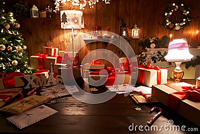 Santa workshop table with Merry Christmas tree, gift boxes pile on xmas night. Stock Photo