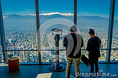 SANTIAGO, CHILE - OCTOBER 16, 2018: Inside view of of couple standing close to a coin viewer machine with the city of Editorial Stock Photo