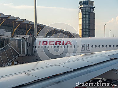 Parts of an IBERIA airplane in front of the tower and the departure gate of the local airports Editorial Stock Photo