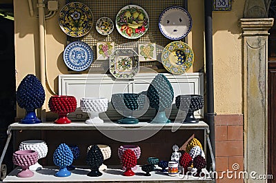 Detailed view shelves with different colorful vases, jugs, plates. Gift shop in the street Editorial Stock Photo