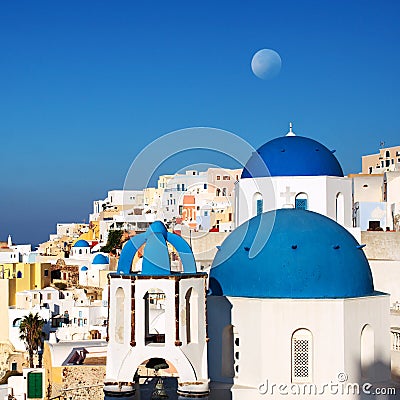 Santorini blue dome churches with moon. Oia Village, Greece. Stock Photo