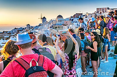 SANTORINI, GREECE - JULY 12, 2014: Tourists enjoy sunset in Oia Editorial Stock Photo