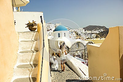 Santorini, Greece - September 11, 2017: Teenager girls or tourists traveling together taking pictures and recording video vlogs in Editorial Stock Photo