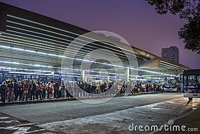Passengers wait in line for buses at the Santana Bus Terminal at night, north side of Sao Editorial Stock Photo