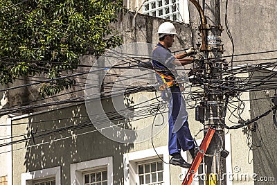 Company employee outsourced maintains an electric power transformer Editorial Stock Photo